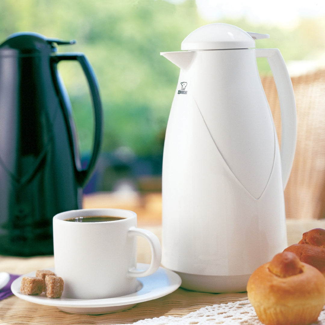 Zojirushi Flasks UAE - Stylish white and black insulated flasks with coffee and pastries on a table.